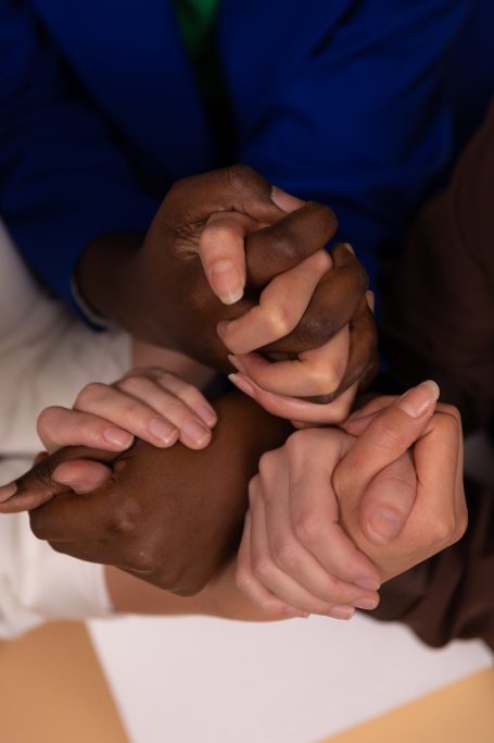 Diverse hands clasped together, symbolising unity and support.